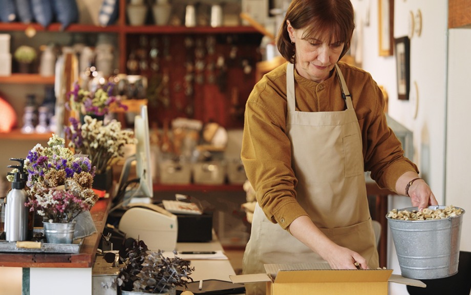 shopkeeper at florist preparing a package for shipping