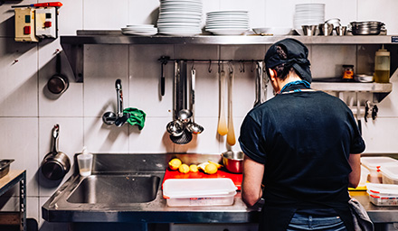 Photo: Immigrant cook working alone in a kitchen